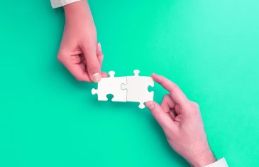 two hands with jigsaw puzzle