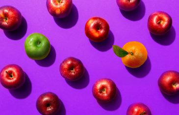 Apples and oranges on purple background