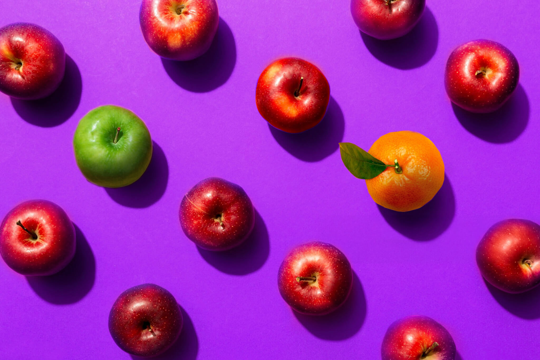 Apples and oranges on purple background