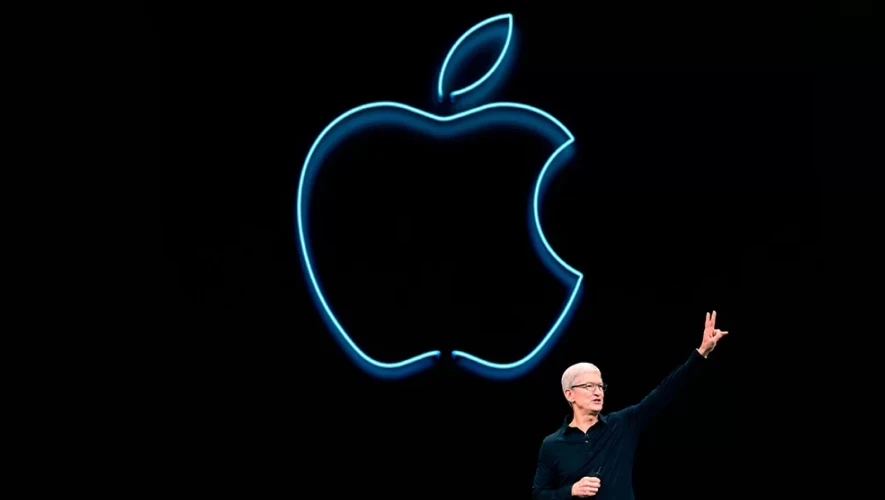 Apple logo on a black wall, a man in front with his hand up