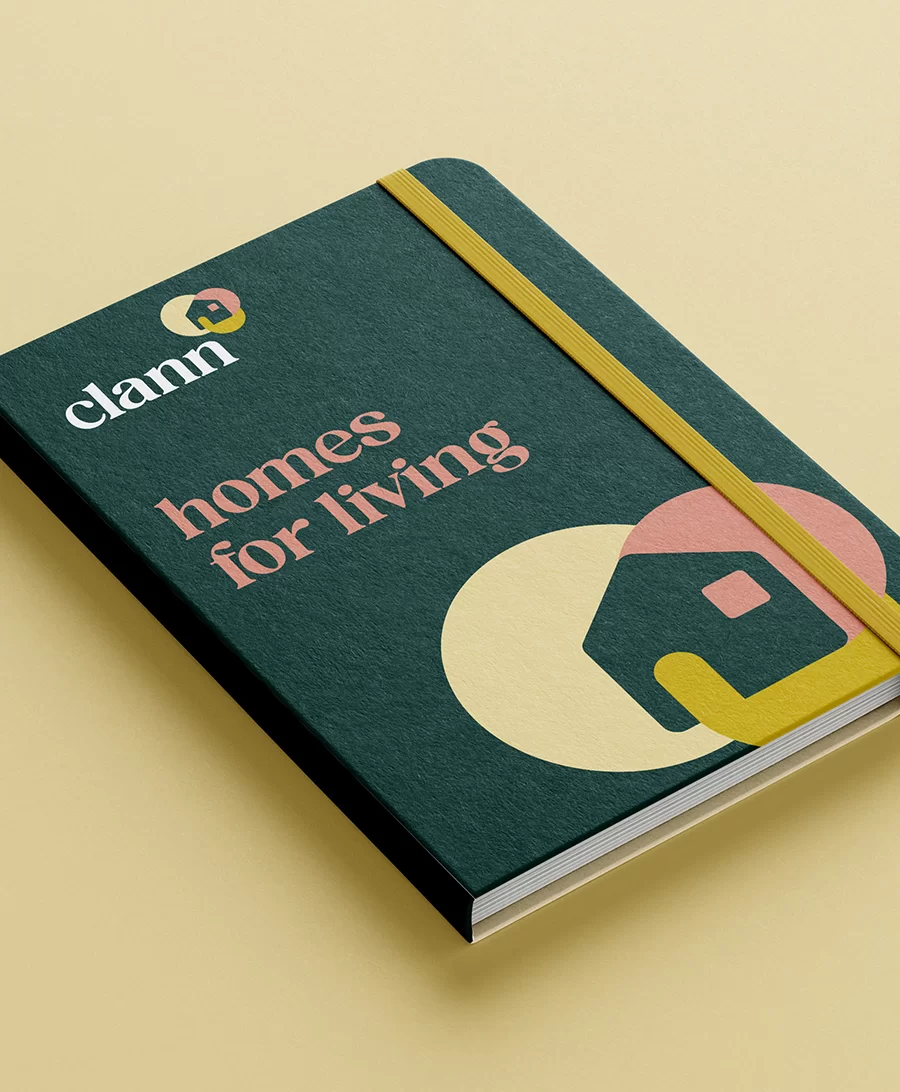 a branded notebook with Clann branded colours, logo and motif