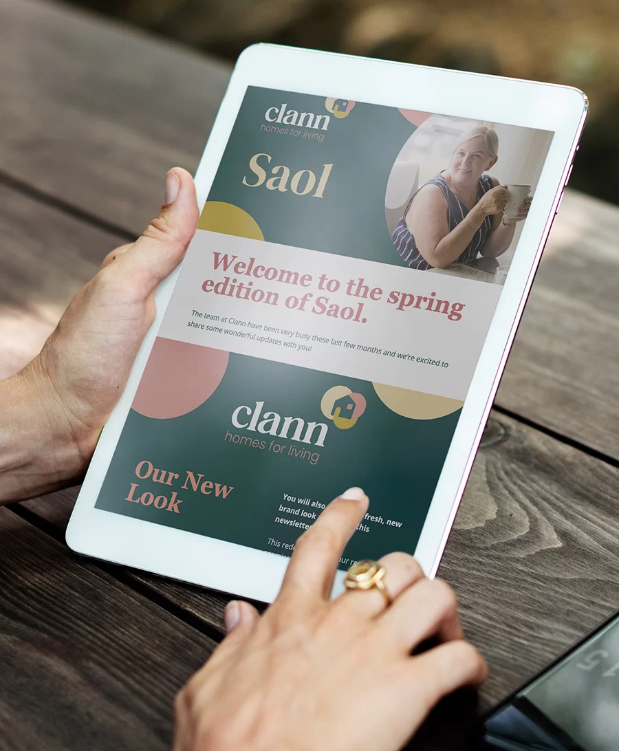 a portrait tablet in hands scrolling through an email newsletter from Clann